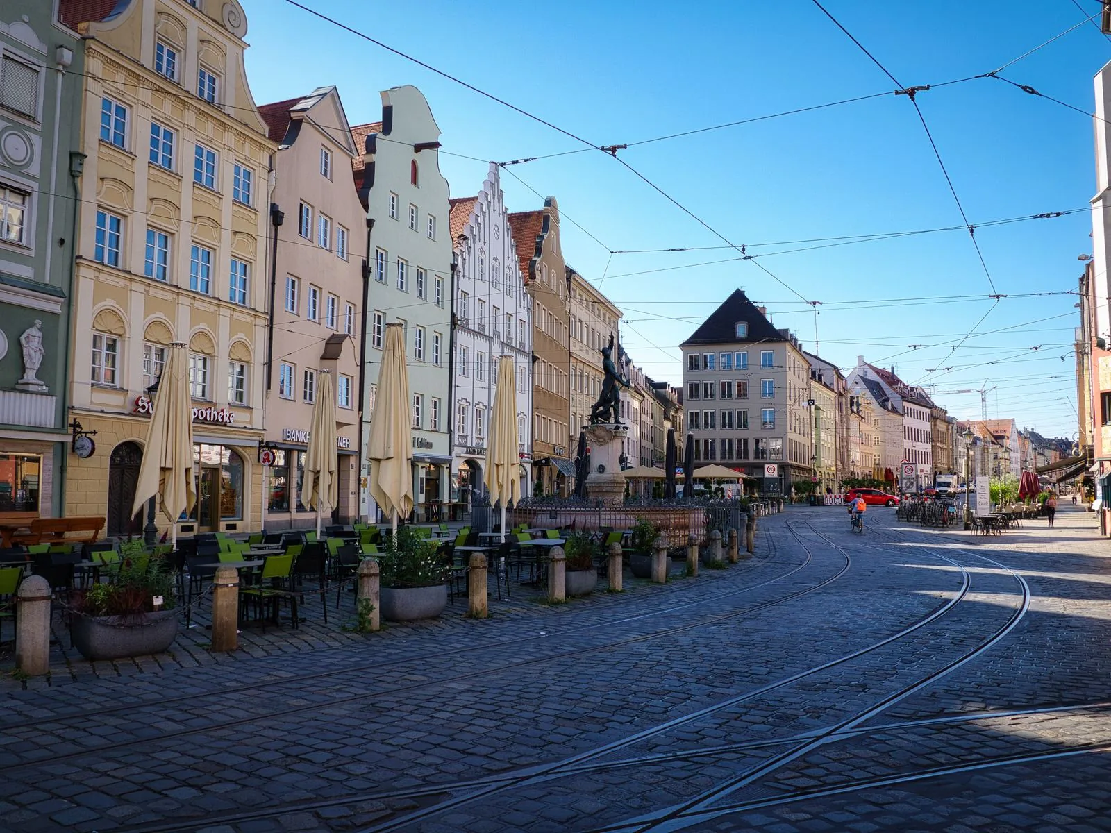 Die Maximilianstraße in Augsburg mit Kopfsteinpflaster, Straßenbahngleisen und historischen Giebelhäusern